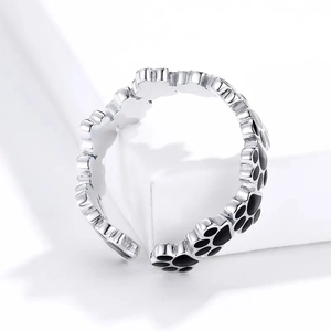 Makroaufnahme des verstellbaren Pfotenabdruck-Rings mit schwarzen Emaille-Details