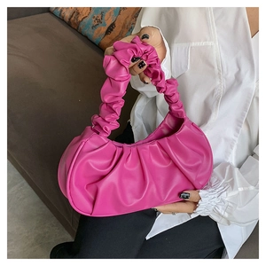 Close-up of pink pleated cloud bag with soft leather texture and stylish ruched handle