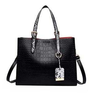 Black crocodile embossed tote bag with snake skin handles and gold hardware detailing
