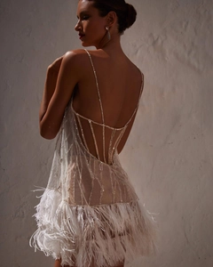 Close-up of sparkling sequin embroidery and ostrich feather trim on the open back dress