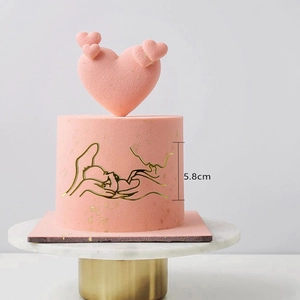 Detail showing pink heart cake topper and 5.8cm golden minimalist line art decoration