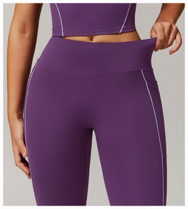 Detalle de mallas de yoga de talle alto con bolsillos laterales y costuras blancas