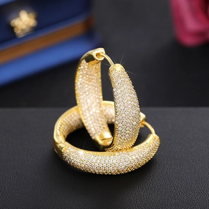 Detailed macro view of gold-plated hoop earrings with micro-pave cubic zirconia inlay
