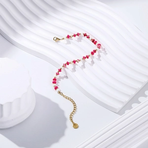 Macro detail of a beaded bracelet with pink stones and stainless steel gold plating