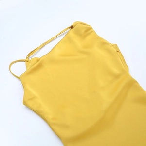 Détail d'une robe de soirée en satin jaune montrant la texture soyeuse et les bretelles