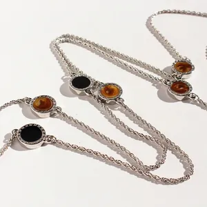 Minimalist silver long sweater chain with round black enamel pendants and twist link design