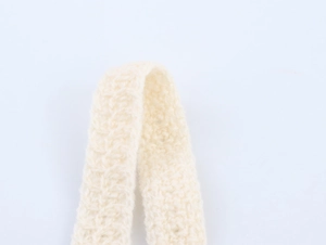 Close-up of cream white crochet strap with thick knit texture for a slim fit summer top