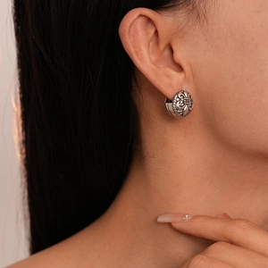 Close-up of vintage silver fleur-de-lis earrings with shimmering white zircon stones