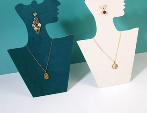 Detail of dark green and cream velvet bust stands for necklace and earring display
