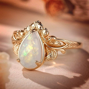 Vintage golden leaf ring with a pear-shaped opal stone and intricate texture details