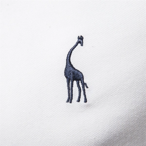 Macro view of navy blue giraffe embroidery on white cotton pique polo shirt fabric