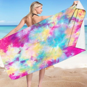 Detailed microfibre beach towel featuring a vibrant 3D tie-dye pattern on a sunny beach