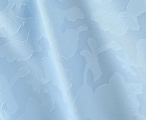 Gros plan sur la broderie florale bleu clair et la texture du tissu jacquard