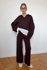 Detail eines dunkelbraunen Stricksets mit V-Ausschnitt-Polo-Pullover und weiter Strickhose