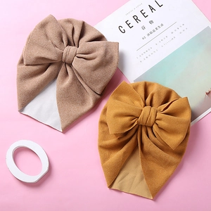 Detailed view of the double-layer bow and texture on warm faux cashmere baby turban hats