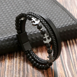 Close-up of multilayer men's leather bracelet with black beads and silver anchor charms