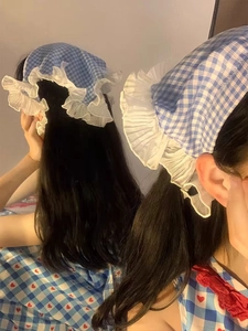 Rear view of French blue checkered lace headscarf with white ruffled edges in home setting