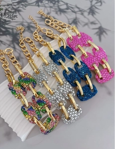 Detail view of colorful rhinestone encrusted pig nose necklaces in a gold link setting