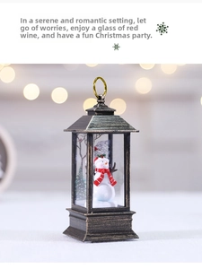 Close-up of a festive Christmas lantern featuring a snowman and tree scene inside