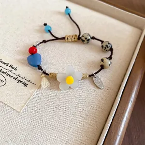 Bracelet perles fait main avec fleur en résine, cœur en pierre et pompon décoratif sur lin
