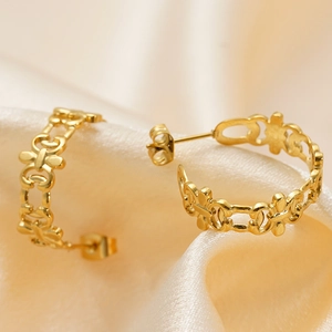 Elegant 18K gold plated stainless steel hollow intertwined earrings on beige silk