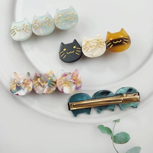 Three-head acetate cat hair clip in marble and amber colors with gold metal base