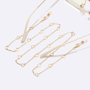 Detailed close-up of golden hollow heart metal links on the eyewear chain and rubber grips