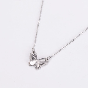 Detailed close-up of a silver butterfly pendant with textured wings and fine link chain
