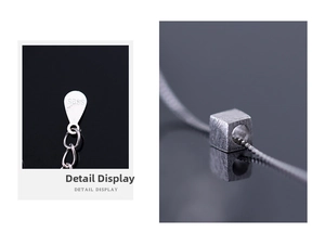 Macro shot of S925 sterling silver stamp and frosted cube pendant on fox tail chain