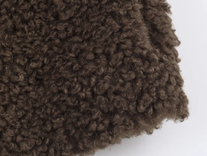 Detailed close-up of soft dark brown teddy fleece fabric texture for women's zipper jacket