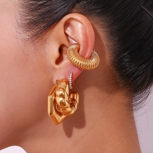 Detailed close-up of 18K gold-plated stainless steel chunky hoop earrings and ear cuff