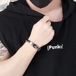 Détail d'un bracelet multicouche en cuir noir tressé avec boucle en acier sur le poignet