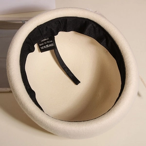 Detailed interior of a 100% wool beret with black sweatband and adjustable drawstring