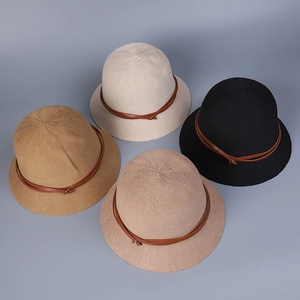 Flat lay of breathable knitted bucket hats in four colors with brown leather strap detail