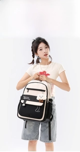 Black and white stylish school backpack with plush cloud charm shown on 168cm model