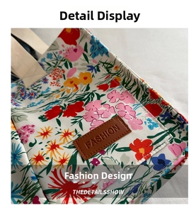 Detail of floral canvas tote bag featuring a leather patch and woven handles