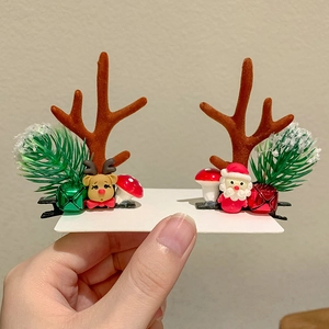 Close-up of Christmas reindeer antler hair clips with bells and festive deer doll decor