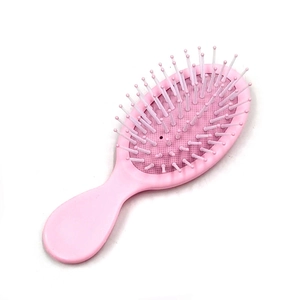 Detailed top view of pink massage hairbrush with soft round bristles and plastic frame