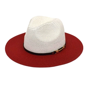 Détail d'un chapeau de soleil bicolore en paille avec bande noire et boucle dorée élégante