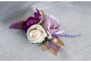 Close-up of handmade wrist corsage with white roses and lavender for wedding guests