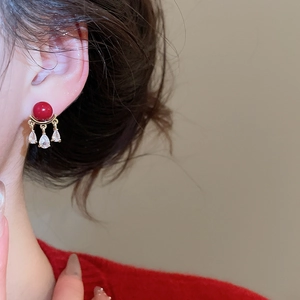 Model wearing vintage red pearl earrings with triple gold-set teardrop crystals
