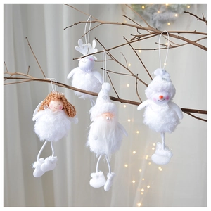 Close-up of plush angel and reindeer ornaments hanging on branches with warm light