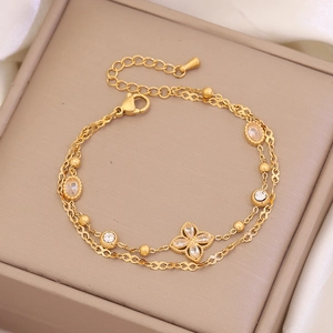 Double-layer gold clover bracelet with zircon accents on a jewelry gift box
