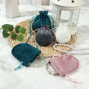 Thick velvet drawstring pouches in multi-color for jewelry storage on a marble surface