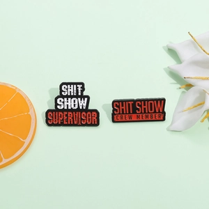 Funny Shit Show Supervisor and Crew Member enamel pins on a fresh green background