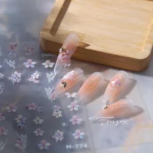Detail van M-774 nagelstickers met bloem- en vlinderontwerpen op roze nagels