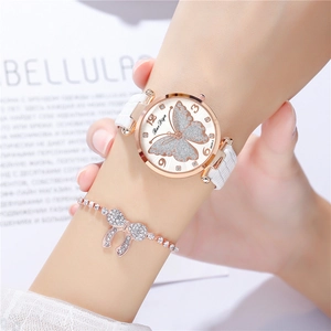 Macro view of leather watch band and rose gold case with sparkling butterfly dial