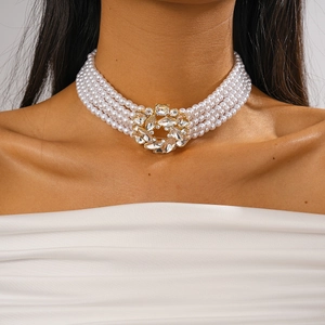 Detail of multi-layer pearl choker with a sparkling crystal-encrusted center on neck