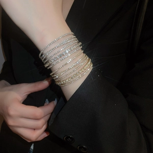 Close-up of multilayer silver-tone tennis bracelets with sparkling rhinestones on wrist
