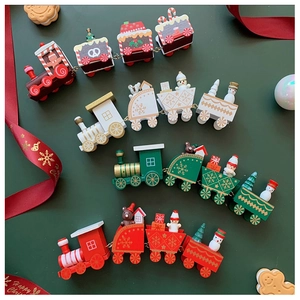 Flat lay macro of colorful wooden Christmas train sets on a festive dark green background